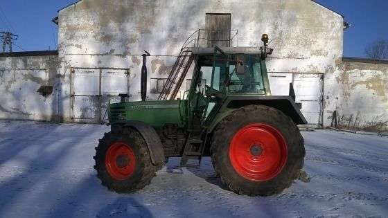 Używany ciagnik rolniczy Fendt 310 na tle zabudowań gospodrstwa widom na lewy bok pojazdu 