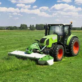Zielony traktor rolniczy CLAAS i kosiarka lekka czołowa dyskowa TORO podczas koszenia trawy www.korbanek.pl