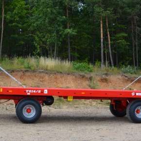 Czerwona przyczepa do transportu bel model T014/2 firmy Metal-Fach o ładowności 9000 kg