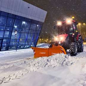 Czerwony traktor rolniczy wraz z pomarańczowym spychaczem do śniegu CITY 200 firmy Samasz podczas odśnieżania ulicy www.korbanek.pl