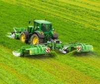 Kosiarki dyskowe GigaCUT firmy Samasz wraz z zielonym ciągnikiem rolniczym koszą trawę na łące