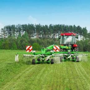 Widok z tyłu zielona zgrabiarka DUO 680 firmy Samasz z czerwonym ciągnikiem zgrabia trawę na jeden pokos www.korbanek.pl