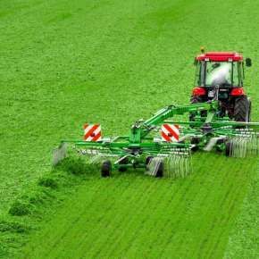 Widok z góry czerwonego traktora z zieloną zgrabiarka DUO 680 firmy Samasz zgrabiającego trawę na jeden pokos www.korbanek.pl