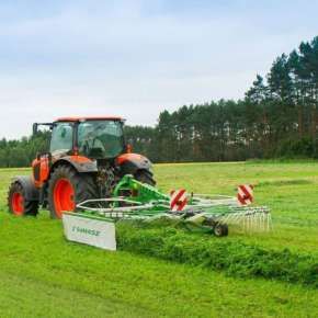 Czerwony ciągnik rolniczy z zieloną zgrabiarką zawieszana Z-410 firmy Samasz zgrabia skoszoną trawę www.korbanek.pl