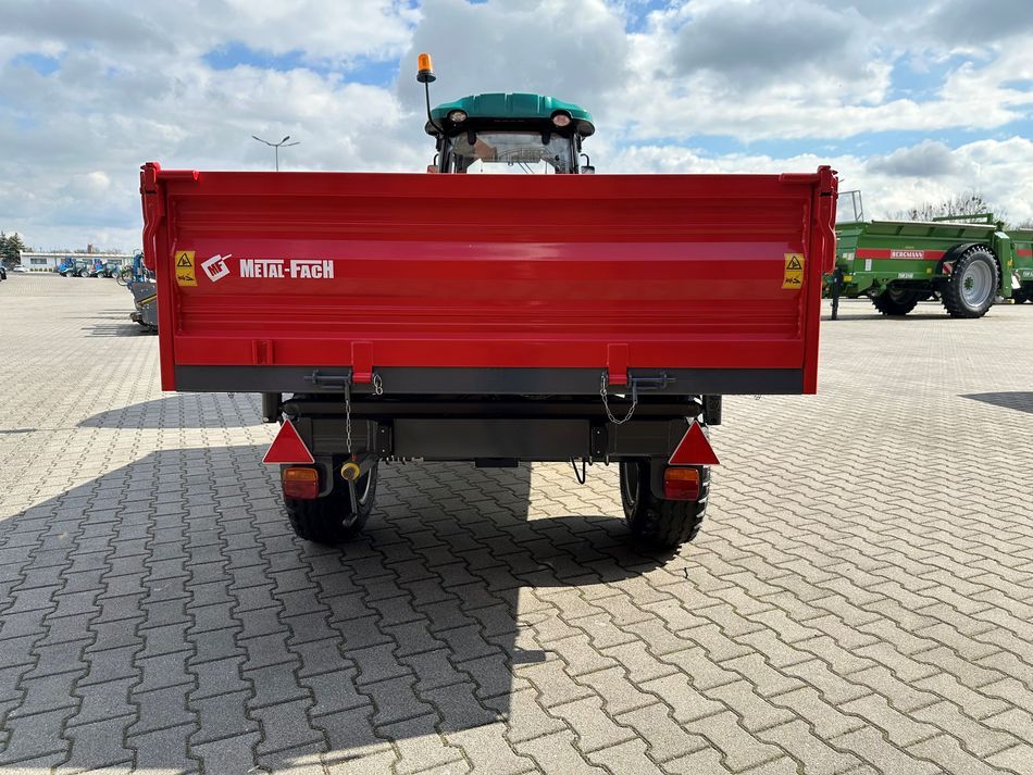 Czerwona przyczepa wywrotka T735C/1 o ładowności 3200 kg firmy Metal-Fach podczepiona do ciągnika ARBOS 3055