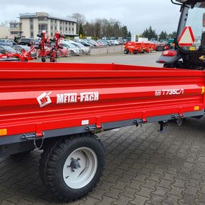 Czerwona przyczepa wywrotka jednoosiowa T735C/1 o ładowności 3,2 tony firmy Metal-Fach na placu firmy Korbanek