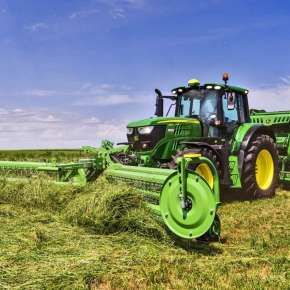 Zielony traktor John Deere z prasą rolującą i zgrabiarką grzebieniową czołową Twist 600 firmy Samasz zbiera trawę www.korbanek.pl