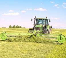 TWIST czołowa zgrabiarka do trawy Samasz pracuje razem z zielonym traktorem na łące Korbanek.pl