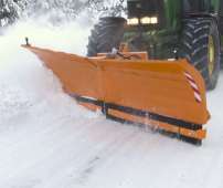 Spychacz do śniegu Alps firmy Samasz pług do odśnieżania zaczepiony na zielonym ciągniku odśnieża drogę 