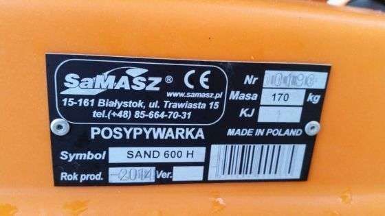 Pomarańczowa tabliczka znamionowa na czarnej posypywarce piasku i soli Samasz Sand 400