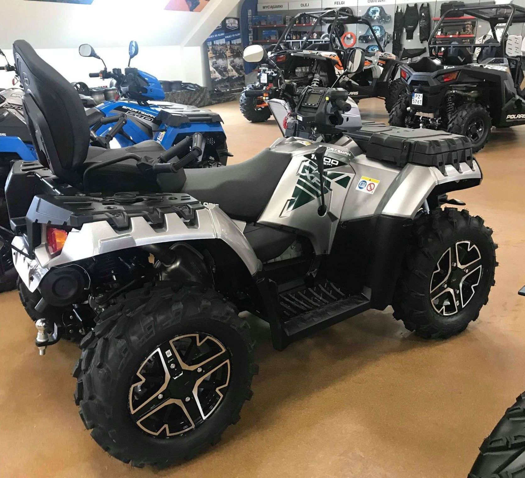 Quad Polaris Sportsman 1000 Touring Srebrny metalik Quad Polaris Sportsman 1000 Touring na tle innych modeli pojazdów Polaris