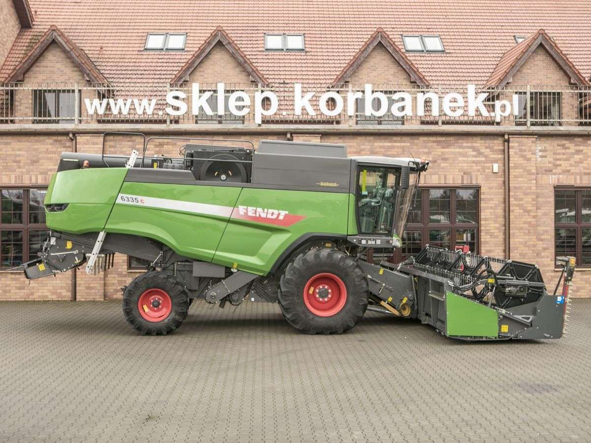 Prawy bok używanego kombajnu Fendt 6335 na tle spółki Korbanek 