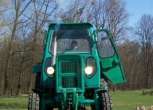 Przód używango ciągnika rolniczego Belarus na tla zieleni 