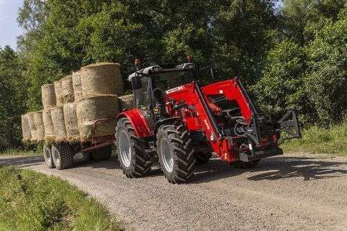 Ciągnik rolniczy Massey Ferguson podczas transportu balotów