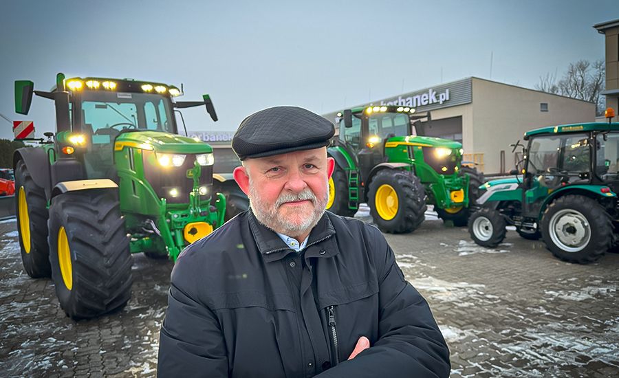 Korbanek na tle ciągników John Deere