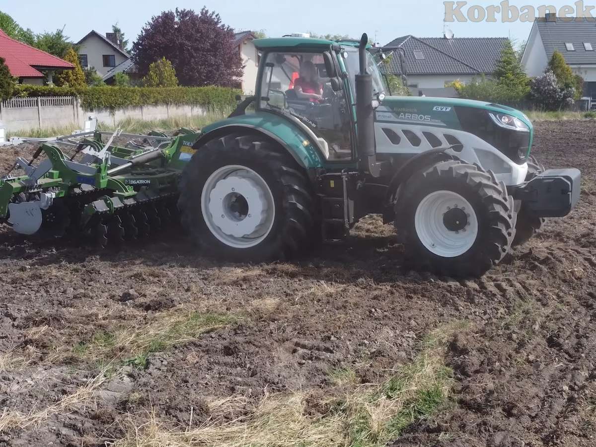 Zielono biały ciągnik Arbos z talerzówką