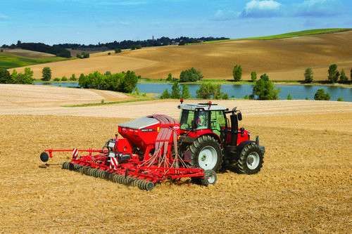 Ciągnik Massey Ferguson z agregatem w trakcie prac na polu