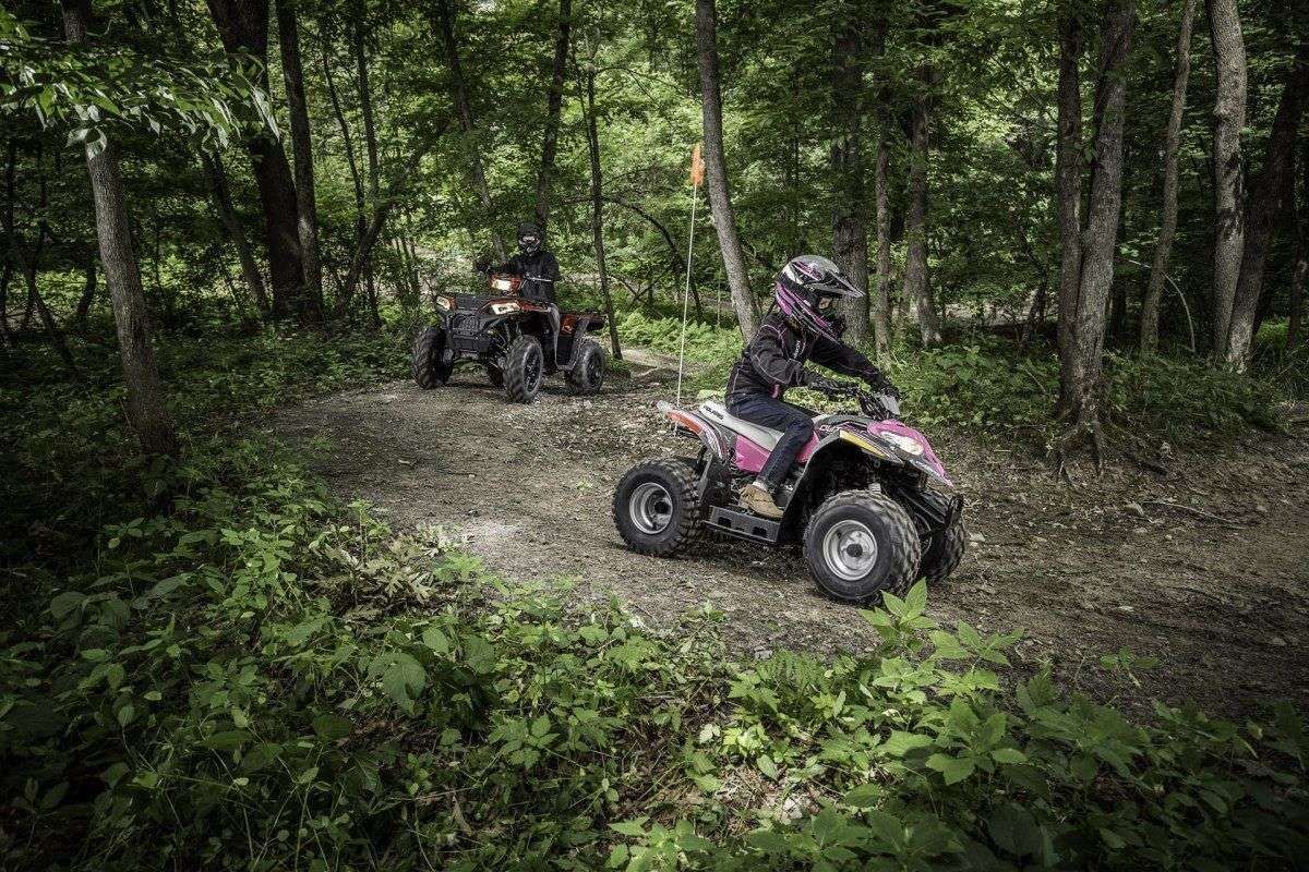 Dzieci jażdżące po lesie Quadami Polaris Outlaw od www.korbanek.pl Dzieci jażdżące po lesie Quadami Polaris Outlaw na przedzie rózowy quad za nim czarno -czerwony