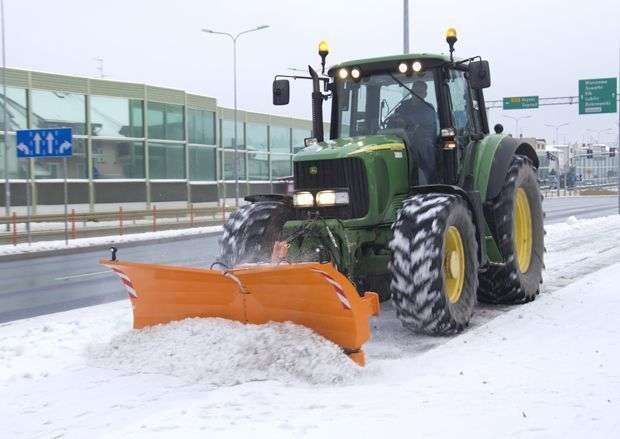 PSV popularny spychacz do śniegu Samasz Pług do śniegu PSV firmy Samasz. Pomarańczowy spychacz zawieszony na ciągniku John Deere odśnieża ulicę