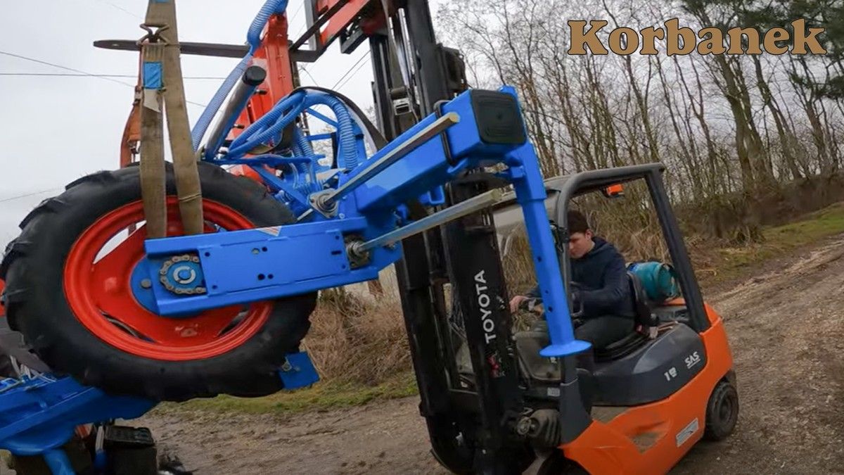 Syn Klienta za pomocą wózka widłowego ściąga siewnik Monosem z naczepy